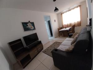 a living room with a couch and a television at AGUA MAIS in Campos dos Goytacazes