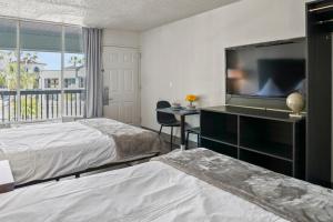 a bedroom with two beds and a flat screen tv at Stayable St Augustine in St. Augustine