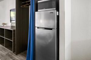 a stainless steel refrigerator in a kitchen with blue curtains at Stayable St Augustine in St. Augustine