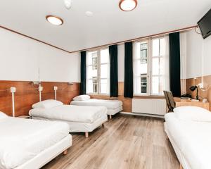 a hospital room with four beds and a tv at Hotel van Gelder in Amsterdam