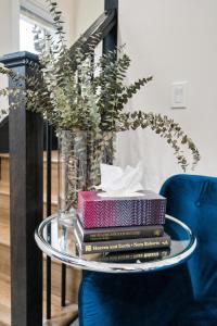 a stack of books on a glass table with a vase at Parker Guest House in Vancouver