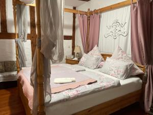 a bedroom with a canopy bed with pink and white pillows at Jurahaus Hirschberg EG Wohnung in Beilngries