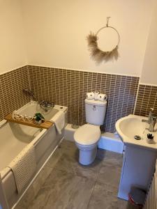 SWANSEA MARINA VIEW mins to beach, Marina, Swansea Arena, City free parking في سوانسي: حمام مع مرحاض وحوض استحمام ومغسلة