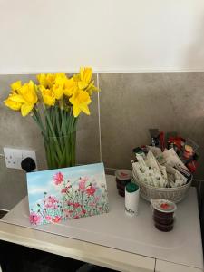 un tavolo con un vaso di fiori e una foto di SWANSEA MARINA VIEW mins to beach, Marina, Swansea Arena, City free parking a Swansea