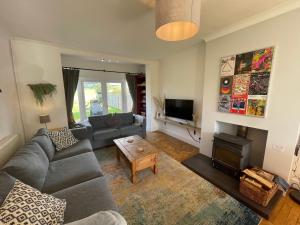 a living room with a couch and a fireplace at Jamie's Georgeham in Croyde