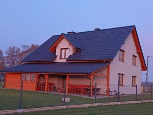 a large house with a blue roof with tables on it at Agroturystyka Kameralna93 in Ochaby