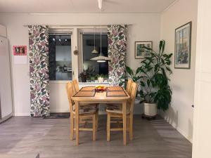 a dining room with a table and chairs and a plant at Standard swedish family house in Ronneby
