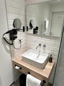 a bathroom with a sink and a mirror at Alpenglühen Smart Hotel in Olching