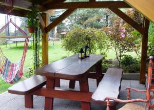 a wooden picnic table and benches under a gazebo at Pod Jednym Dachem in Skawa