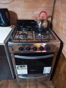 a stove with a tea kettle on top of it at Departamento LA LILI in Uspallata