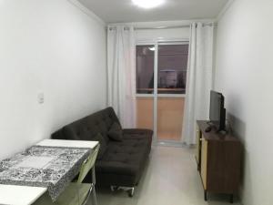 a living room with a couch and a television at Pasqualetto in Caxias do Sul