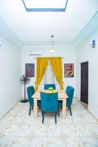 a dining room with a table and blue chairs at AJI Luxury 3BED Apartment (Ijegun, Lagos) in Lagos