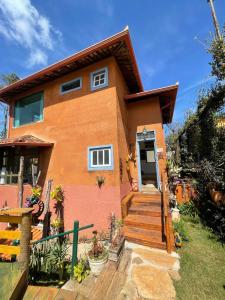 une maison avec un escalier en face de celle-ci dans l'établissement Casa das Orquídeas, à Lavras Novas