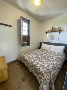 1 dormitorio con cama y ventana en Casa das Orquídeas en Lavras Novas