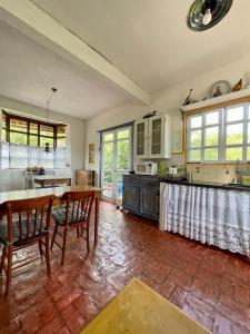 a large kitchen with a table and chairs in it at Casa das Orquídeas in Lavras Novas