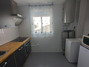 a small white kitchen with a window and a sink at San Juan nº10 in Jaén