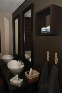 a bathroom with a sink and two mirrors at Tranquil Garden Nest in Nelspruit