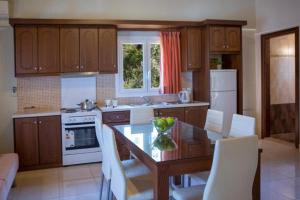 a kitchen with a wooden table and white appliances at Liotrivi Apartments in Vasiliki