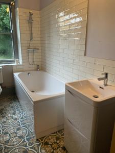 a bathroom with a white tub and a sink at Cosy cottage in the heart of Bakewell in Bakewell