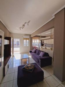 a living room with a purple couch and a table at Viktoria Sea View Apartment in Perea