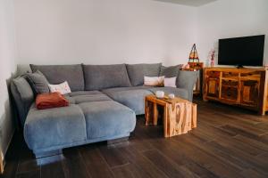 a living room with a blue couch and a table at Ferienwohnung Im Schafftl 10 in Ramsthal