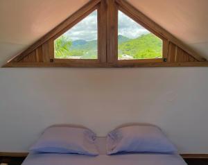 a window above a bed with blue pillows in a room at El Mangle Suite Front Beach in Ayampe