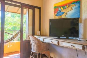 a flat screen tv sitting on top of a dresser at Pousada Vila Tamarindo Eco Lodge in Florianópolis