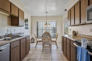 een keuken met houten kasten en een tafel met stoelen bij Beachview Condo #54484 in Holmes Beach