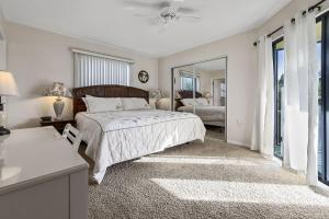 een slaapkamer met een bed en een spiegel bij Beachview Condo #54484 in Holmes Beach