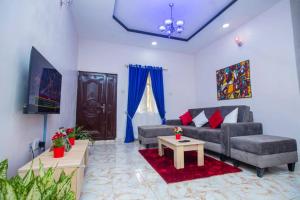 a living room with a couch and a tv at AJI Warm 2BED Apartment (Ijegun, Lagos) in Lagos
