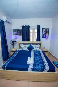 Un dormitorio con una gran cama azul con sábanas azules en AJI Warm 2BED Apartment (Ijegun, Lagos) en Lagos