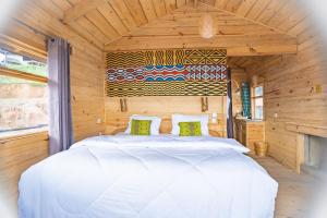 Nyungwe Nziza Ecolodge في Kitabi: غرفة نوم بسرير في كابينة خشبية