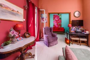 deux photos d'un salon aux murs roses dans l'établissement Aegina's Flowers house, à Égine