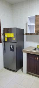 eine Küche mit einem Kühlschrank mit gelben klebrigen Tönen darauf in der Unterkunft Piazza Granada in Cali