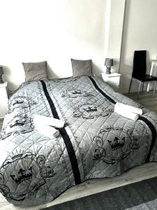 a bed with a black and white comforter and pillows at Zimmervermietung Schöne Gasse 6 in Freiberg