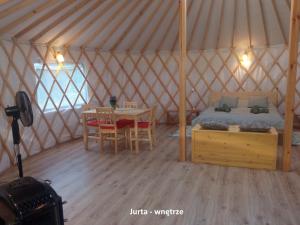 a room with a bed and a table in a yurt at Domek i jurta nad rzeką in Kościerzyna