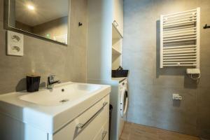uma casa de banho com um lavatório branco e um espelho. em WiguryTower Apartaments 65 em Lódź