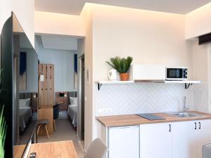 ニドリにあるCaptain's Seafront Apartmentsのキッチン(白いキャビネット、カウンタートップ付)
