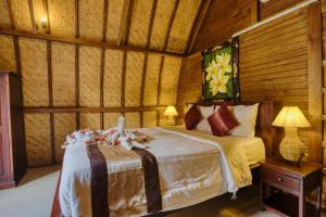 una camera da letto con un letto in una stanza con pareti in legno di The Catar Cottages a Nusa Penida