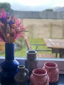 un grupo de jarrones y flores en el alféizar de la ventana en Casa K, en Middelkerke