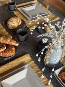 een tafel met borden brood en een vaas met bloemen bij Casa K in Middelkerke