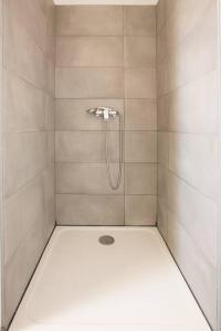 a shower with a shower head in a bathroom at Villa en bord de mer SPA / Sauna (N) in Bretteville-sur-Ay