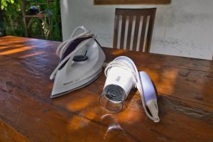 a hair dryer and a bottle on a wooden table at The Catar Cottages in Nusa Penida