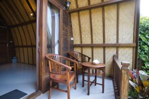 patio con 2 sedie e un tavolo sul portico di The Catar Cottages a Nusa Penida