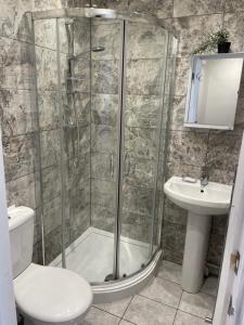 a bathroom with a shower and a toilet and a sink at Double Room with shared bathroom in private self-contained flat you will share with one other person in family house 2 minutes walk from Tufnell Park tube station 15 minutes walk from Camden Town in London