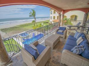 Barrón的住宿－Mazatln Villa Del Mar With Pool，阳台配有藤椅,享有海滩美景