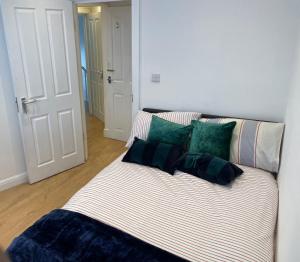 a couch with green and white pillows in a room at Double Room with shared bathroom in private self-contained flat you will share with one other person in family house 2 minutes walk from Tufnell Park tube station 15 minutes walk from Camden Town in London