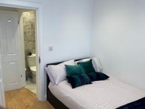 a bed with pillows on it in a room at Double Room with shared bathroom in private self-contained flat you will share with one other person in family house 2 minutes walk from Tufnell Park tube station 15 minutes walk from Camden Town in London