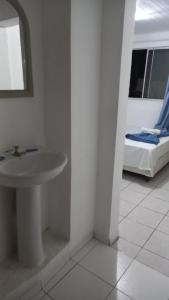 a bathroom with a sink and a bed in a room at Hotel Piazza Batel in Curitiba