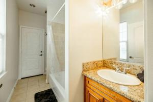 een badkamer met een wastafel, een spiegel en een bad bij Sweet Modern House 7mins to Disney in Fullerton